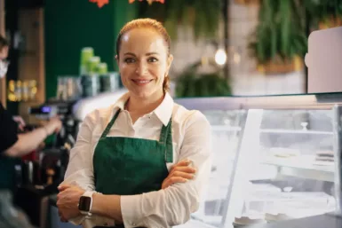 Une commerçante se tient devant sa boutique