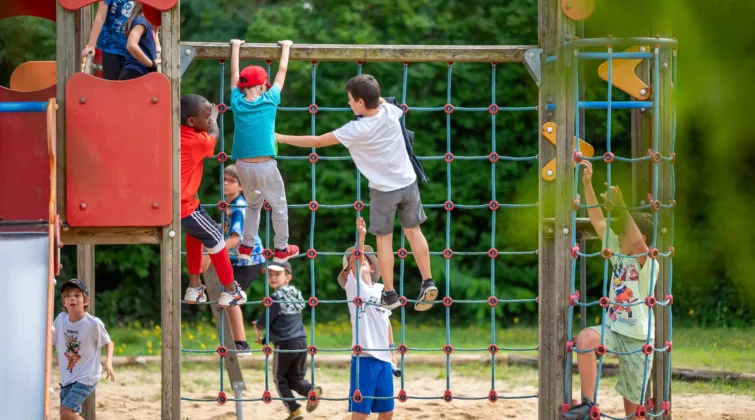Des enfants en tenue d'été jouant sur des jeux de square