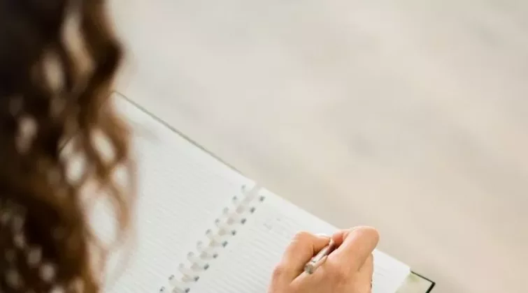 Femme qui écrit sur un cahier