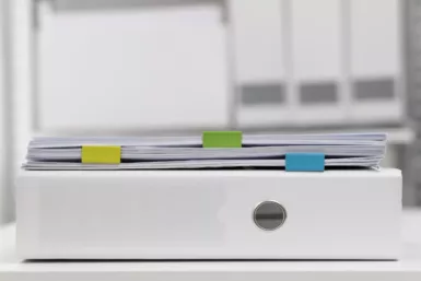 Des dossiers empilés sur un classeur rempli d'actes administratifs