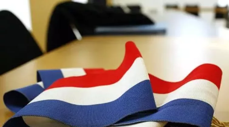 Écharpe tricolore à pompons dorés posée sur une table que le Maire ou les élus peuvent porté