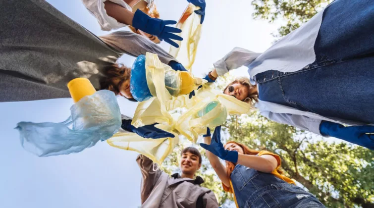 Des jeunes armés de gants ramassent des déchets ; vue en contre-plongée