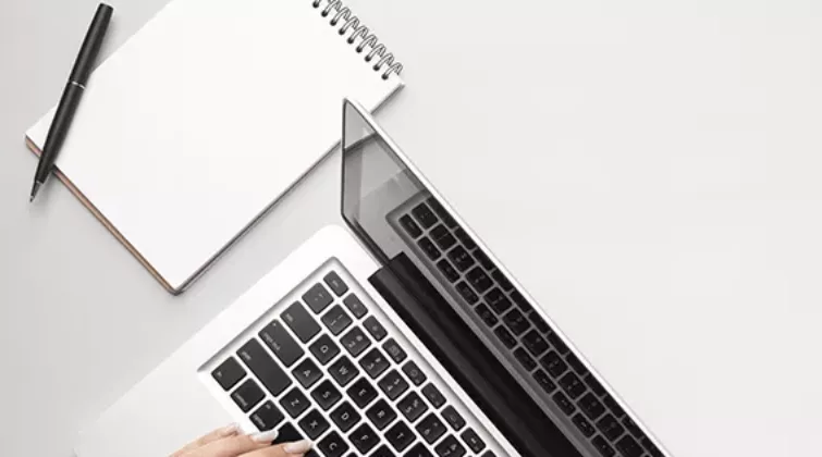 Les mains d'une femme sont posées sur le clavier d'un ordinateur portable ; illustration de la page budget