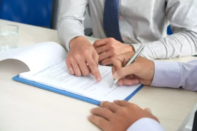 Une personne indique à une autre où signer un document