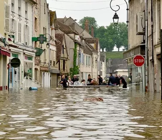 Dans une rue inondée du centre-ville de Nemours, les pompiers évacuent des habitants dans une barque pendant la crue de 2016