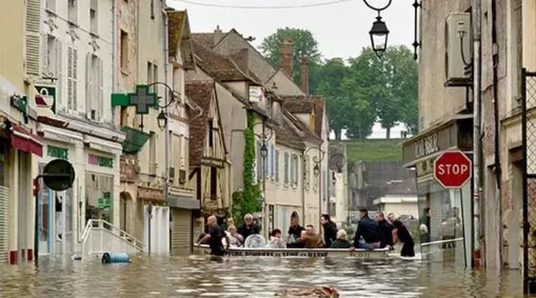 Dans une rue inondée du centre-ville de Nemours, les pompiers évacuent des habitants dans une barque pendant la crue de 2016
