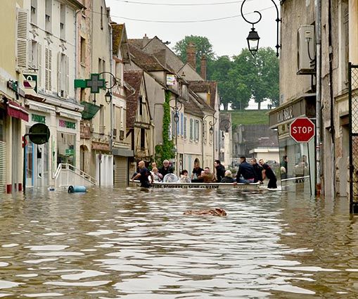 Dans une rue inondée du centre-ville de Nemours, les pompiers évacuent des habitants dans une barque pendant la crue de 2016
