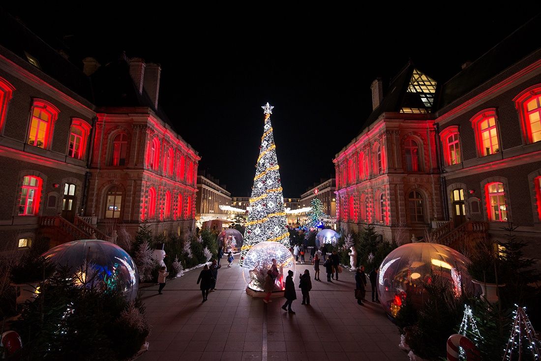 une vue du marché de Noël d'Amiens la nuit, avec les illuminations et le sapin richement décoré