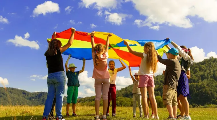 groupe d'enfant debout sur un champ d'herbe verte en plein journée de soleil (Le centre de loisirs)