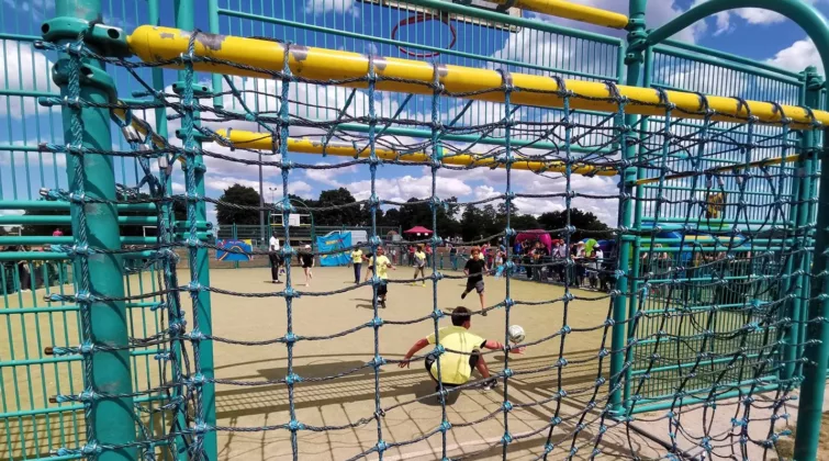 des enfants jouant au foot, vus de derrière les buts, sur le terrain d'aventure de nemours