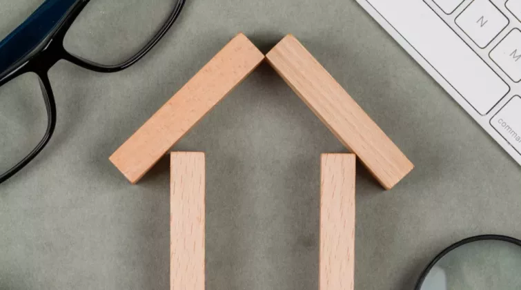 Maison en bois posé sur un table avec des objet autour
