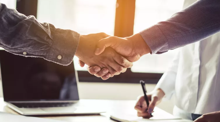hommes qui ce serres la main au dessus de papier de contrat