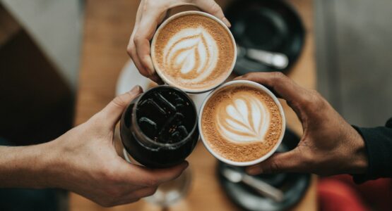 three person holding beverage cups