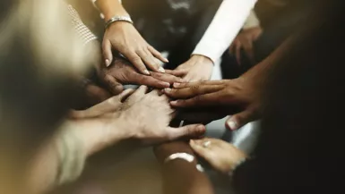 Gros plans sur les mains jointes de différentes personnes. Crédit photo : Freepik