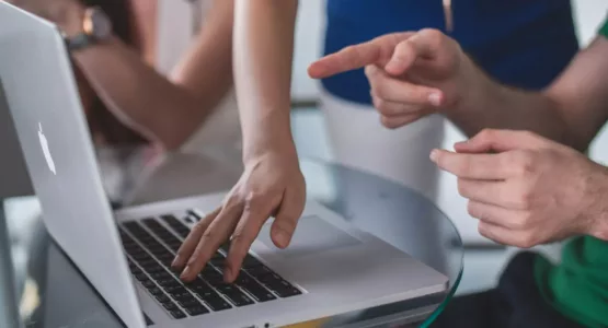 person touching and pointing MacBook Pro