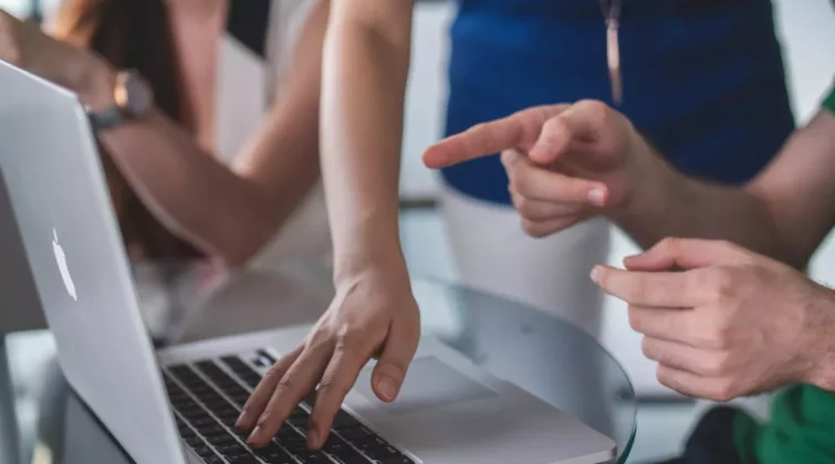person touching and pointing MacBook Pro