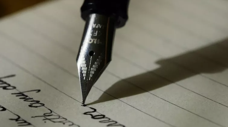 fountain pen on black lined paper